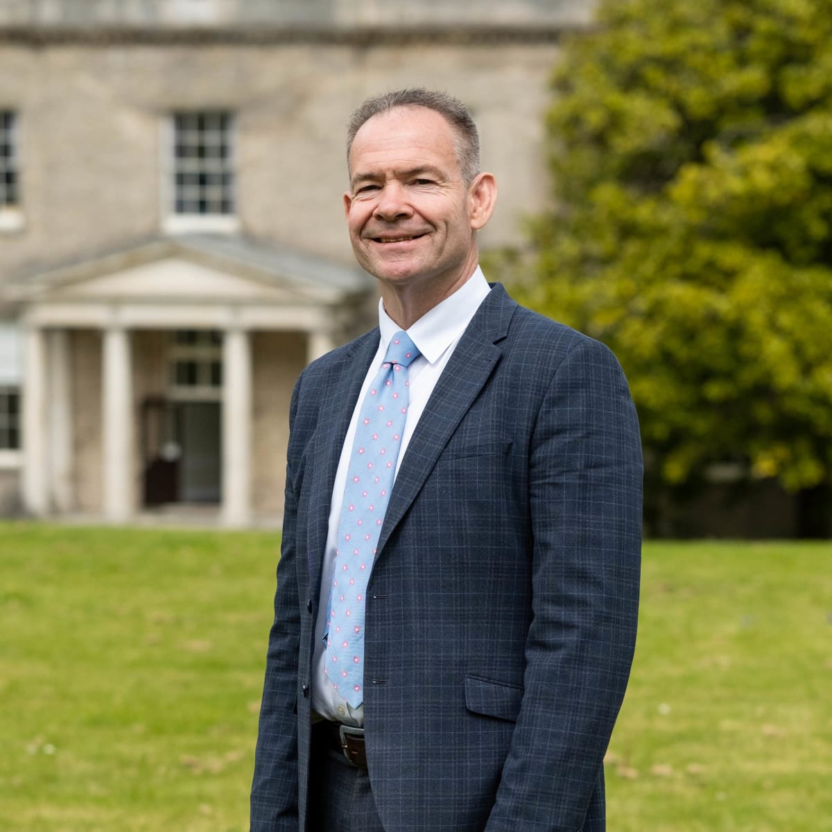 John Green standing outside school building